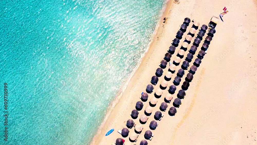 Tropical paradise: Aerial view of a sandy beach with turquoise transparent crystal clear sea water, umbrellas
