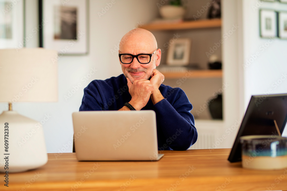 Thinking businessman using laptop while working from home Thinking businessman using laptop while working from home
