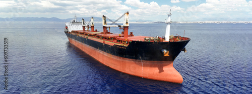 Aerial drone ultra wide panoramic photo with copy space of huge industrial bulk carrier tanker anchored in deep blue Aegean sea