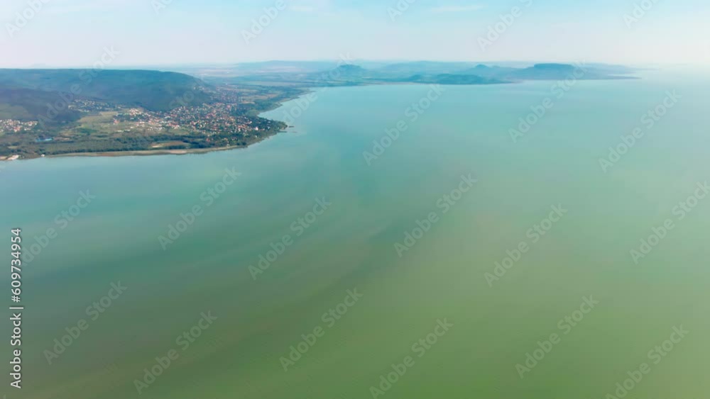 Aerial view of Lake Balaton during Sunny weather in Transdanubian region, Hungary. 4K Drone shot of Shore and Green areas in Summer. Establishing shot of natural landscape in Central Europe Aerial view of Lake Balaton during Sunny weather in Transdanubian region, Hungary. 4K Drone shot of Shore and Green areas in Summer. Establishing shot of natural landscape in Central Europe