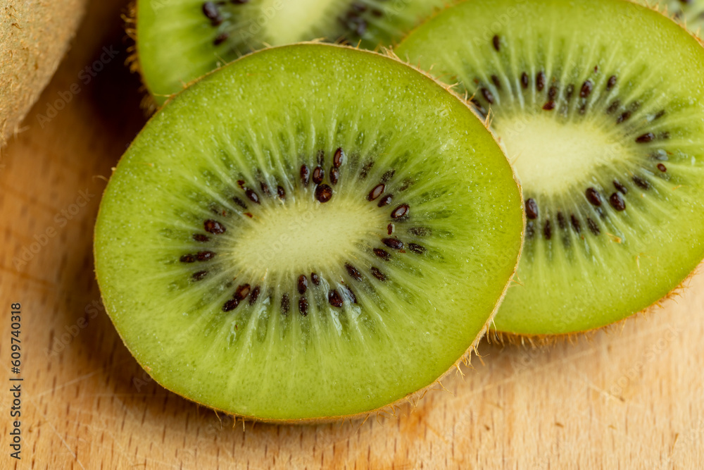 A group of cut green kiwi fruits with black seeds A group of cut green kiwi fruits with black seeds