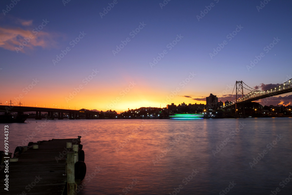 pôr-do-sol em  Florianópolis ao fundo as Pontes Hercílio Luz ,  colombo salles e Pedro Ivo e as luzes de um barco Florianopolis, Santa Catarina, Brasil