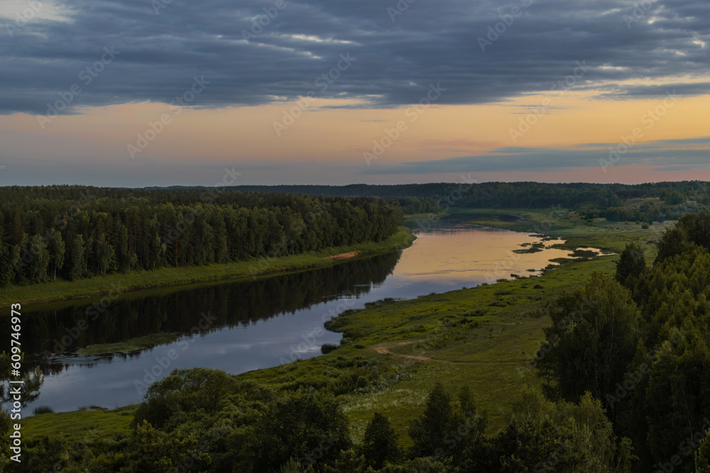 Landscape view on the bend of Daugava river in Naujene parish, Daugavpils district, Latgale region, Latvia, which is a part of Nature Park “Daugavas Loki” at summer after sunset - obrazy, fototapety, plakaty 