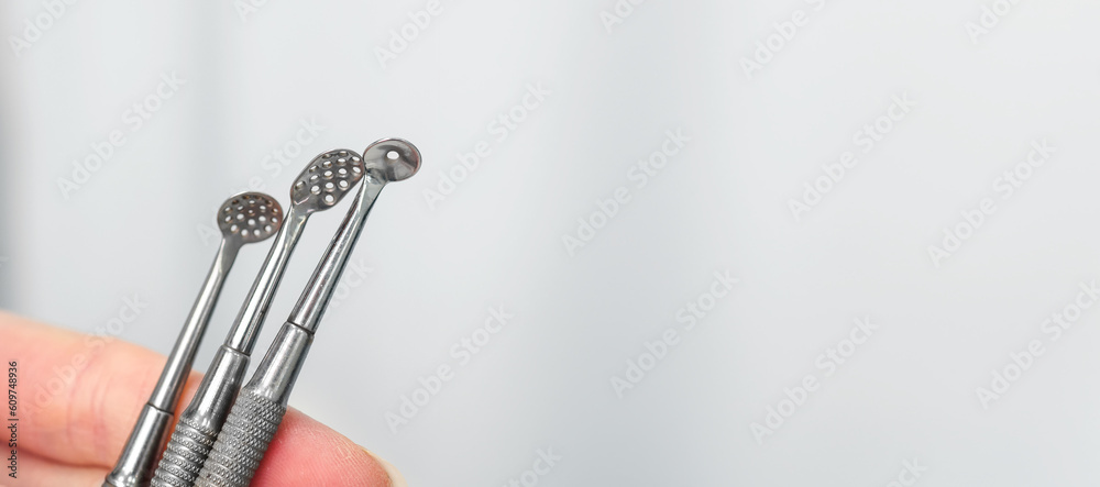 Mechanical facial cleansing Cosmetology metal device close up in beautician hands. Using for procedure for cleansing pores and skin from defects. Banner with copy space Mechanical facial cleansing Cosmetology metal device close up in beautician hands. Using for procedure for cleansing pores and skin from defects. Banner with copy space