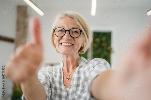 Portrait of one mature blonde caucasian woman with eyeglasses at home