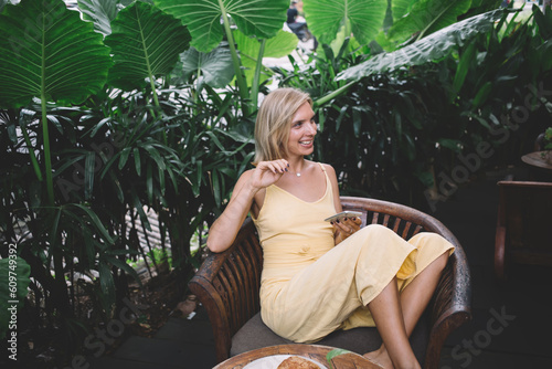 Smiling woman sitting on bench in cafe