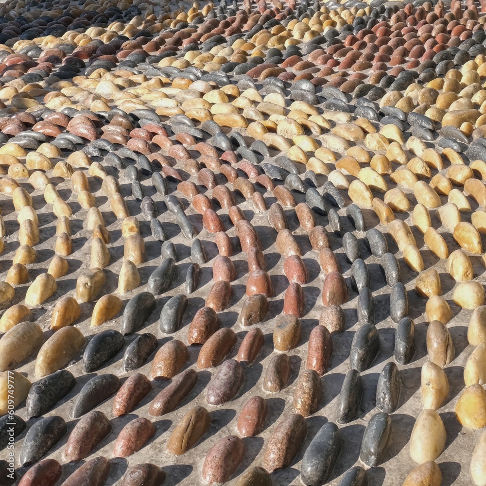 Fragment of reflexology cobblestones pathway for foot massage . Mosaic pattern from convex rounded pebble stones. Textured surface from boulders as background
