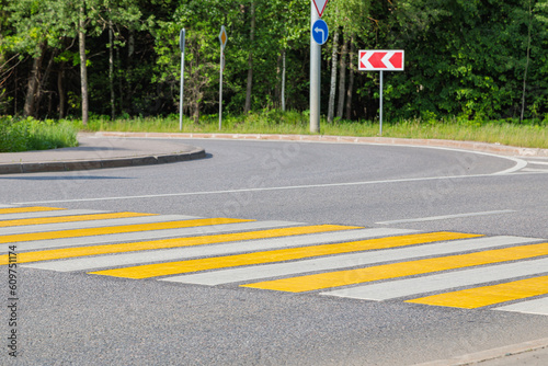 Pedestrian crossing with yellow and white stripes.