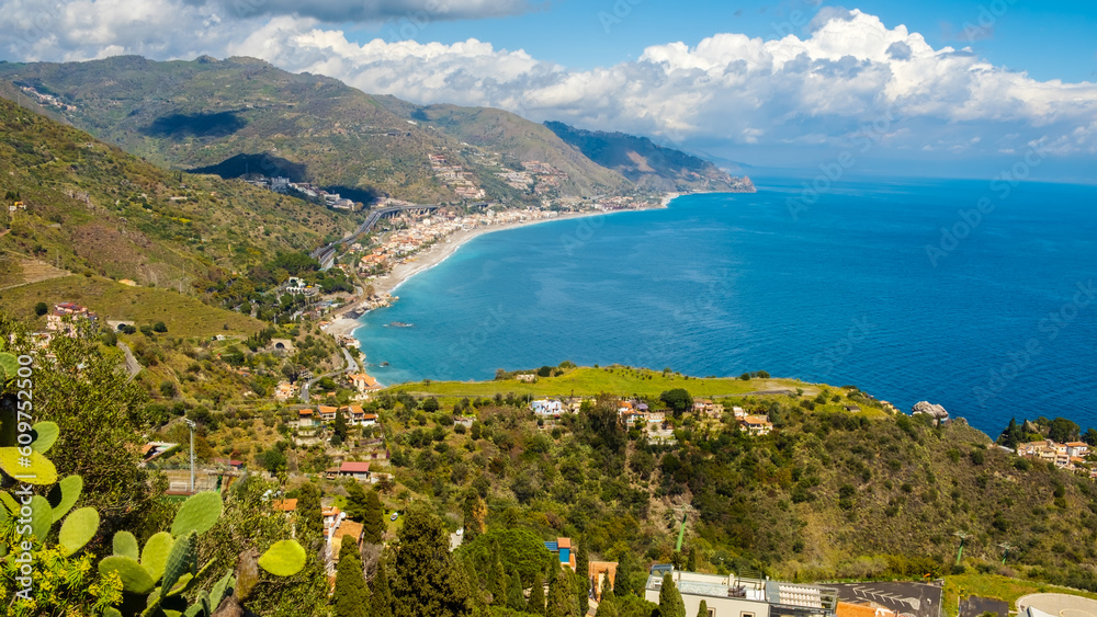 Landscape of Sicialian coast near Taormina town, Sicily, Italy. Mountains and azure waters of Ionian sea. Popular resort and tourist destination in southern Italy