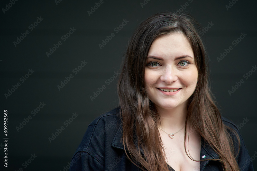 A young girl with green eyes poses on the street on a dark background. Street photo A young girl with green eyes poses on the street on a dark background. Street photo