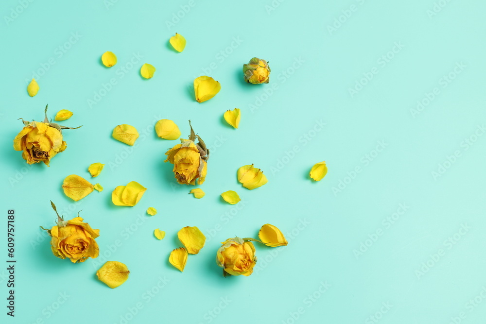 Dried roses flowers on blue background, yellow flowers