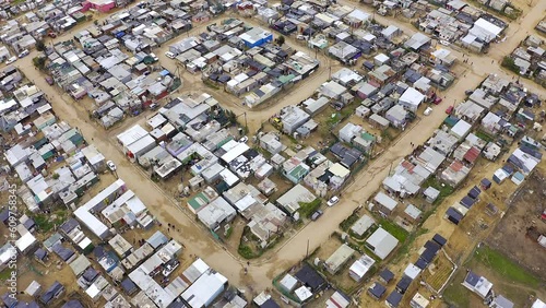 Aerial view, township and shack buildings in South Africa, Gugulethu or neighborhood outdoor. Drone, slums and area, land or landscape with poverty, infrastructure and poor village, street or shanty. photo