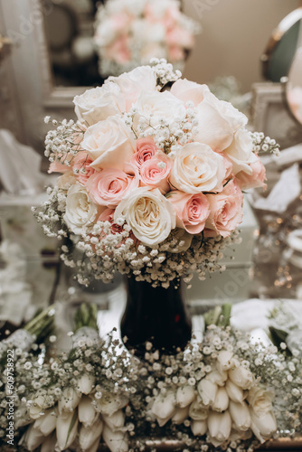 Wedding bouquet of white and pink roses close-up. Fresh beautiful roses in a delicate bouquet for the bride. Wedding accessory in the form of a bridal bouquet. Beautiful flowers in a vase