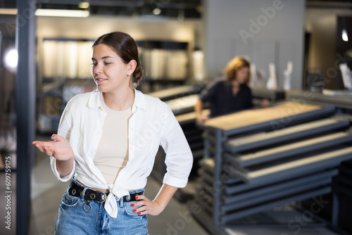 In warehouse of construction store with floor coverings, reflective customer is thinking about expediency of buying laminate flooring in this store photo