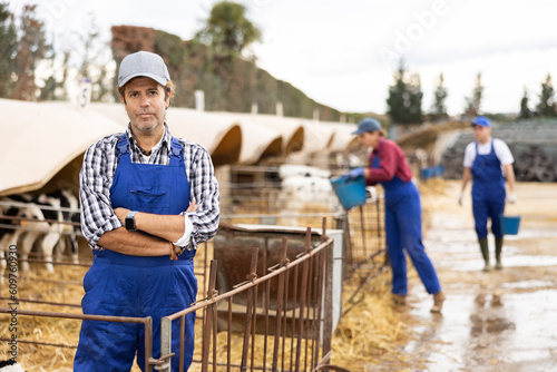 Portrait of positive male farm worker in a cowshed