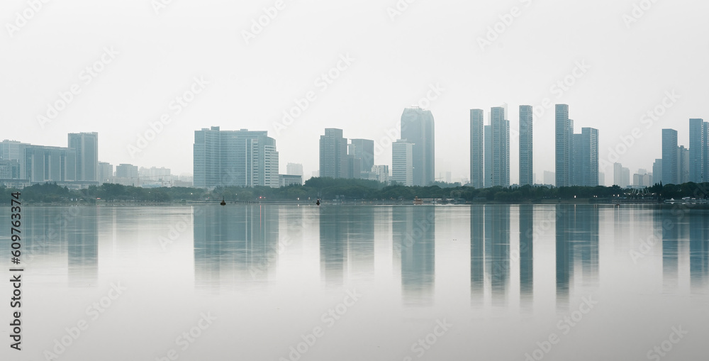 Reflection of modern city buildings in water at morning