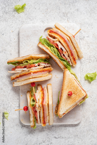 Club sandwich with ham, cheese, tomatoes, lettuce, and toasted bread photo