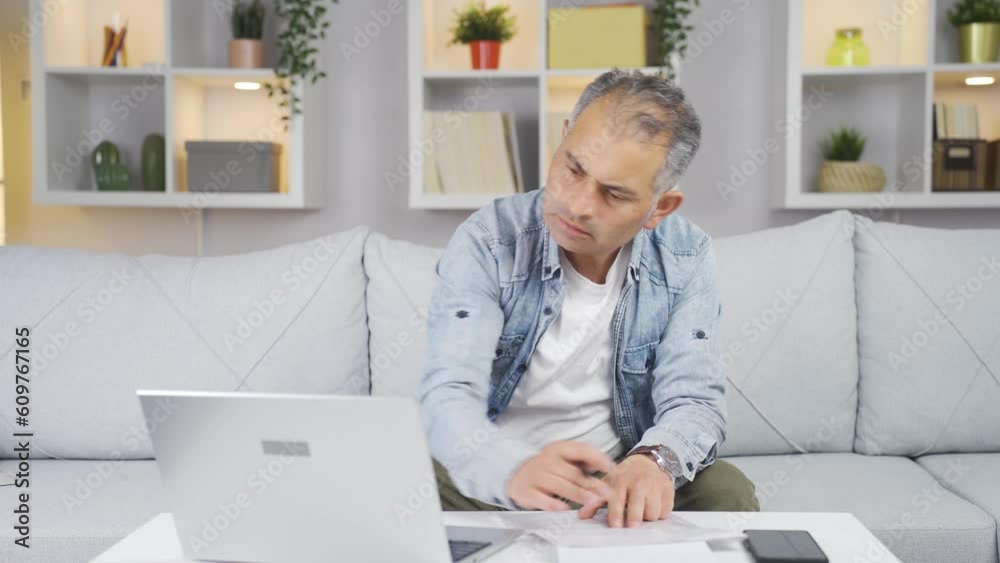 The man looking at the documents is thoughtful. The man looking at the documents is thoughtful.