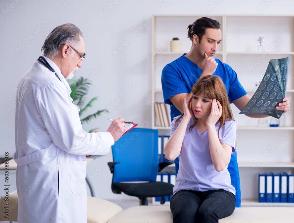 Fototapeta premium Two doctors examining young woman