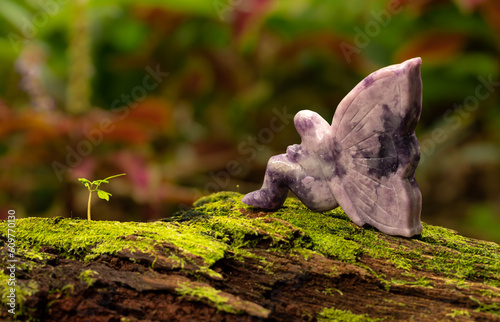 Принти на полотні Lepidolite Fairy Sitting on a Fallen Tree Trunk with Green Moss Nature Backgroun