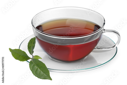 Glass cup of hot aromatic tea and green leaves on white background