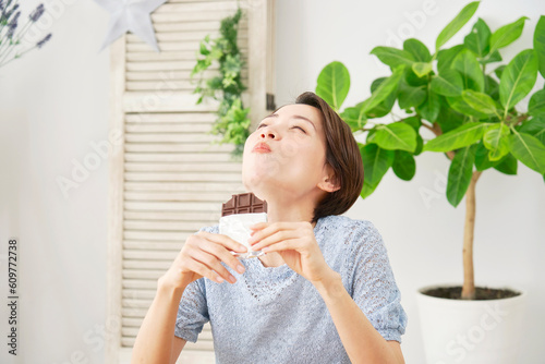 自宅で板チョコを食べる女性