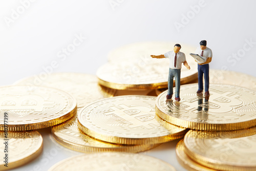 ビットコインの上のミニチュアのサラリーマン