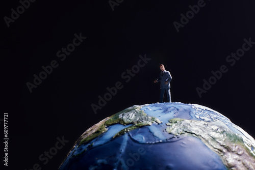 黒い背景に地球の模型とミニチュア人形 photo