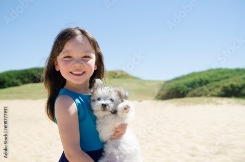 子犬を抱いている笑顔の女の子 photo