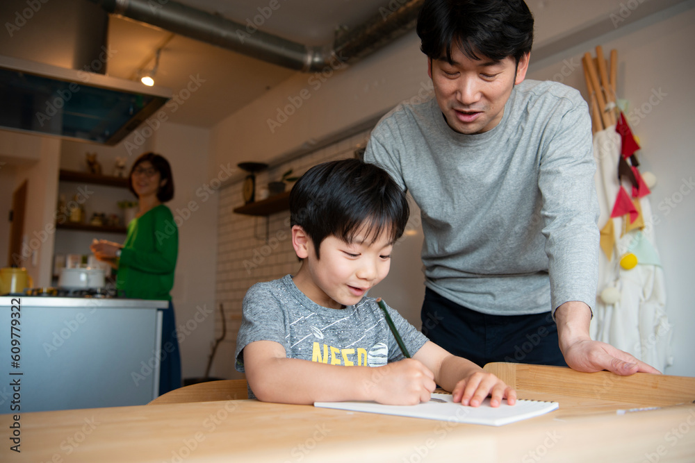 勉強中の男の子と側にいる父親 勉強中の男の子と側にいる父親