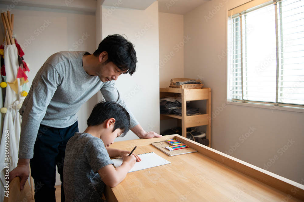 勉強中の男の子と側にいる父親 勉強中の男の子と側にいる父親