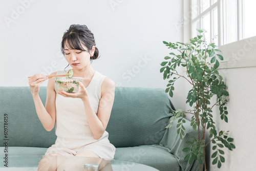 Fotografie 家でサラダを食べるダイエット中の若いアジア人女性（好き嫌い・困る・悩む）