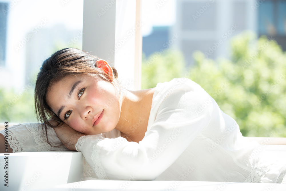 窓辺でこちらを見ている女性 窓辺でこちらを見ている女性