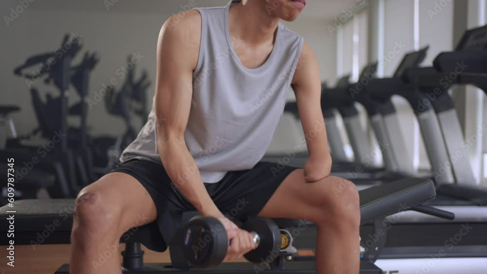 Asian young amputee without arm lift up weight dumbbell in fitness gym. Asian young amputee without arm lift up weight dumbbell in fitness gym.