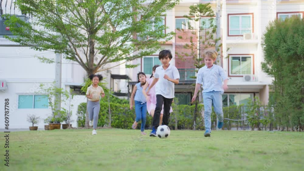 Group of young children playing football outdoors in the school garden. Group of young children playing football outdoors in the school garden.