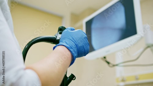 Close-up of doctor's gloved hand with endoscope during diagnostic gastroscopy or colonoscopy in clinic