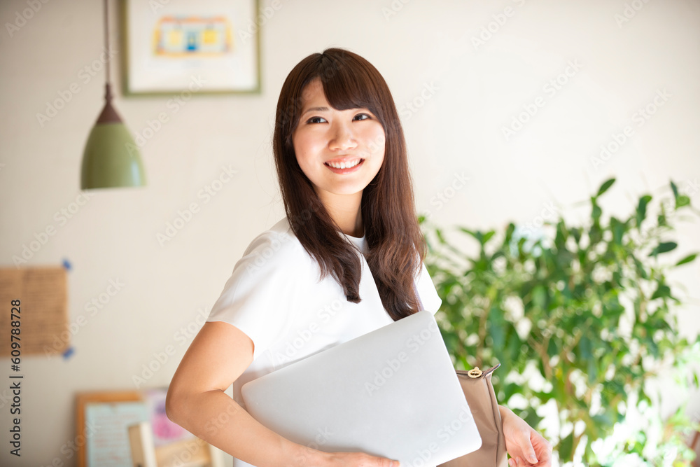 ノートパソコンを抱えて笑っている女性 ノートパソコンを抱えて笑っている女性