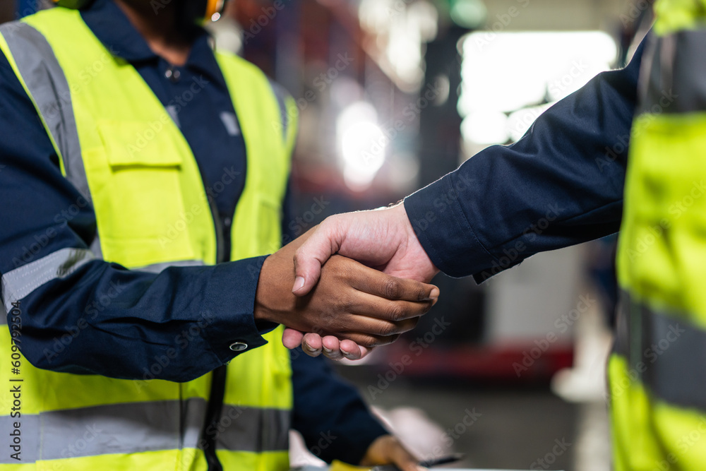 Fototapeta premium Close up of diverse industrial worker doing handshake in manufactory. 