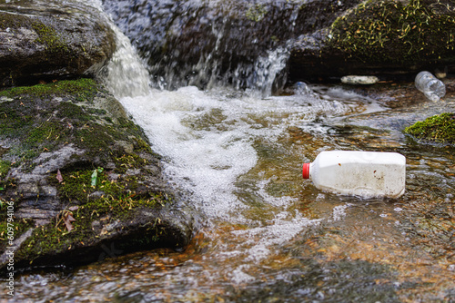 Obraz na plátně Empty Milk Jug litter floating in Pristine Flowing Stream showing environmental