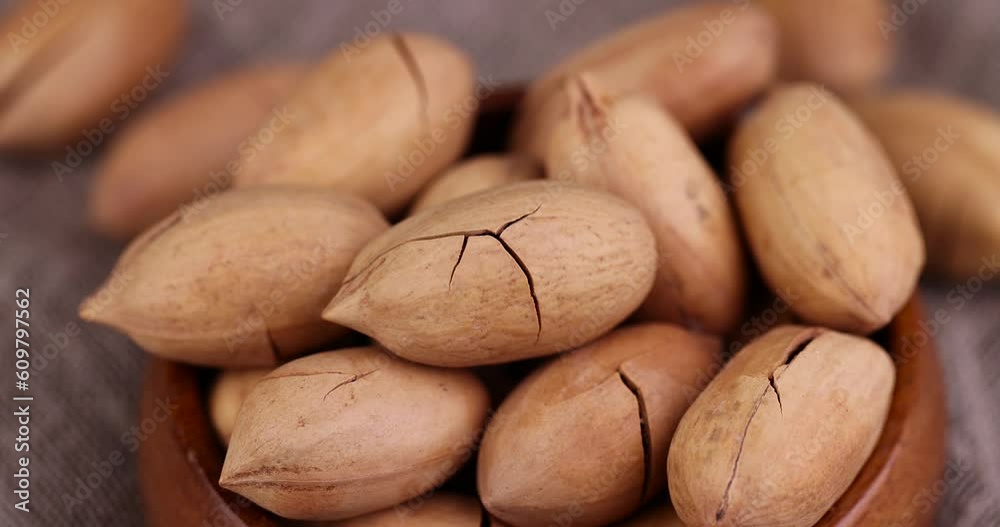Unpeeled crunchy pecans close-up, a large number of unpeeled pecans in the kitchen Unpeeled crunchy pecans close-up, a large number of unpeeled pecans in the kitchen