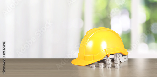 Yellow hardhat model house and coin with trading graph