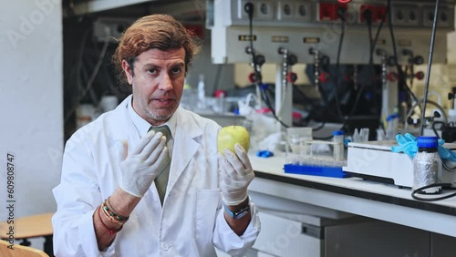 Geneticist working in laboratory, injecting additives into apple during experiments with genetically modified fruits