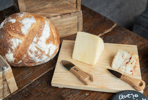Queso, tabla de quesos y pan recién horneado. 