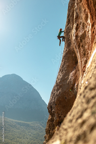 Girl climbing rocks, rock climbing. like sports and recreation. sports girl is engaged in rock climbing.