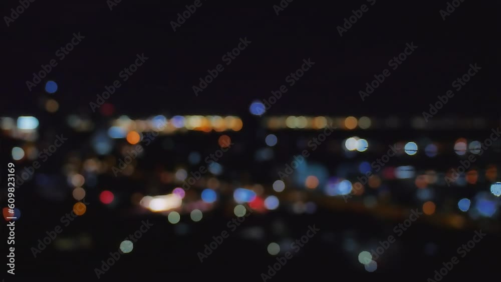 Footage video, defocused blurry motion colorful bokeh of city night light traffic, abstract dark background of cityscape, element template, overlay effect