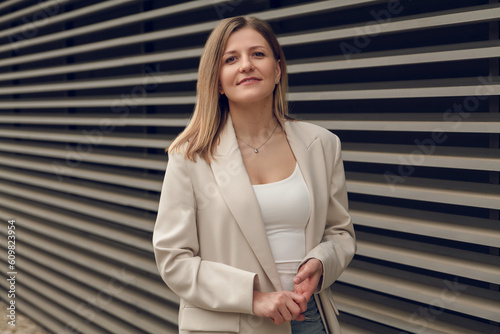 Confident businesswoman standing near striped wall