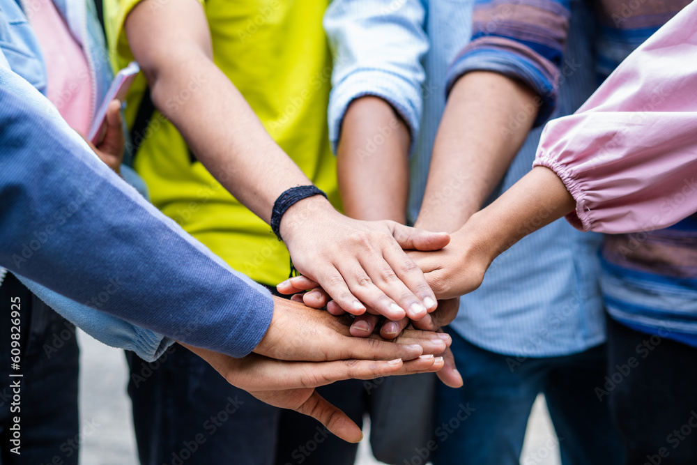 Close up shot group of students joining hands at college campus for cause - concept of teamwork, unity friendship and community support. Close up shot group of students joining hands at college campus for cause - concept of teamwork, unity friendship and community support.