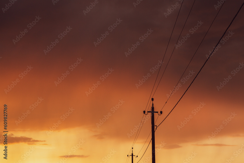 High-voltage power lines at sunset. Electricity distribution station. Electricity pylons on the background of the sky.
