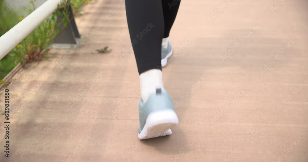 운동화를 신고 걸어가는 여성의 다리 운동화를 신고 걸어가는 여성의 다리