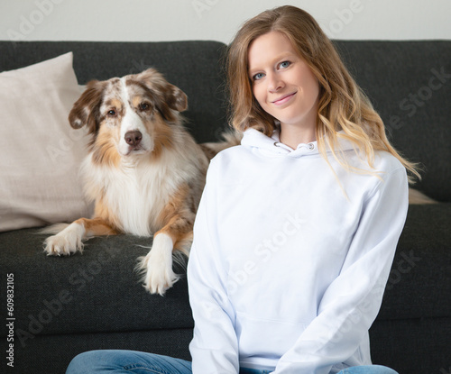 Frau mit Hund Australian Shepherd weißer Pullover Hoodie Jeans Mockup Indoor Sofa Zuhause Kissen Couch